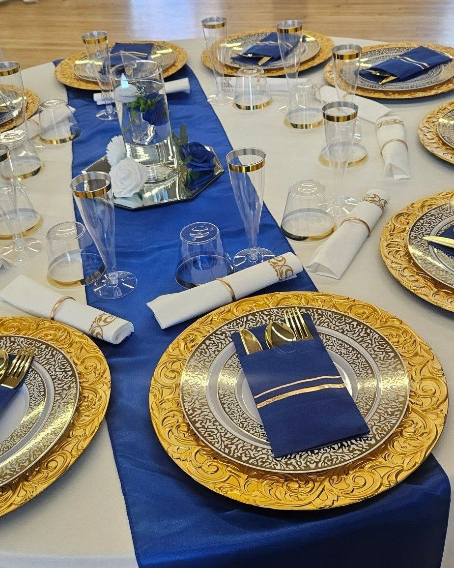 Gold-scroll charger plate with a navy napkin and gold flatware, place setting detail