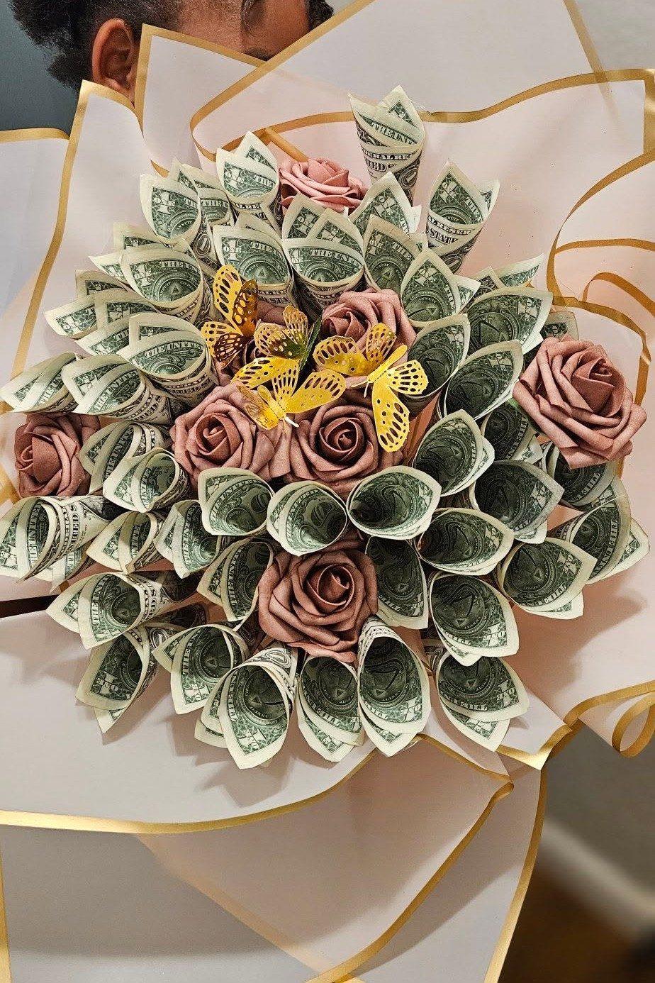 A hand-tied celebration bouquet styled with paper roses and gold butterfly accents